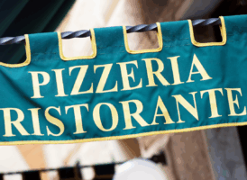 A green banner sign with "PIZZERIA RISTORANTE" in yellow letters.