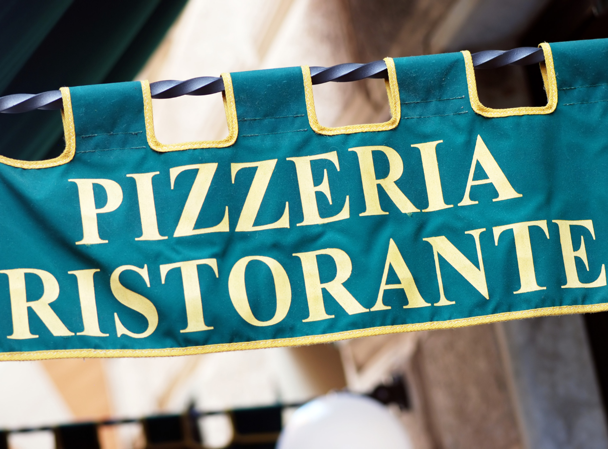 A green banner sign with "PIZZERIA RISTORANTE" in yellow letters.