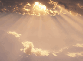 Sun rays breaking through clouds in a warm-toned sky.